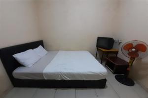 1 dormitorio con 1 cama, ventilador y TV en SPOT ON 92911 Wisma Jaya Syariah 