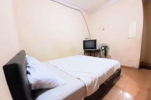 Dormitorio pequeño con cama y TV en SPOT ON 92911 Wisma Jaya Syariah 