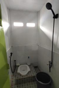 y baño pequeño con aseo y ducha. en SPOT ON 92911 Wisma Jaya Syariah 