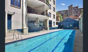 a swimming pool in front of a building at Garden Terrace, Pool & Gym - Trendy Hideaway in Sydney