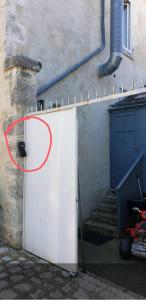 un cerchio rosso su una porta bianca accanto a un edificio di Studio meublé centre ville de mer a Mer