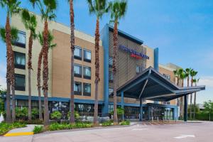 a building with palm trees in front of it at Springhill Suites by Marriott Anaheim Maingate in Anaheim