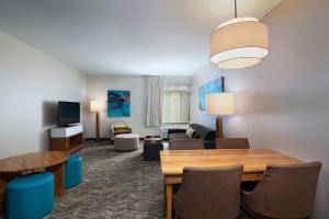 a living room with a table and a living room with a couch at Springhill Suites by Marriott Anaheim Maingate in Anaheim