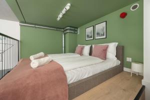 ein Schlafzimmer mit einem großen Bett mit rosa und weißen Kissen in der Unterkunft Airport Studio Zarembowicza by Renters in Breslau