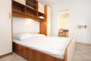 a bedroom with a large bed with wooden shelves at Apartments and rooms by the sea Pag - 3152 in Pag +113 photos