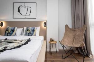 1 dormitorio con 1 cama y 1 silla en New & Stylish 1 bedroom apartment near Fabrika, en Tiflis