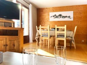 a dining room with a table and two glasses on a table at Appartement au cœur de La Clusaz (50m des pistes) in La Clusaz +6 photos