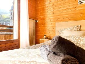 um quarto com uma cama e uma parede de madeira em Appartement au cœur de La Clusaz (50m des pistes) em La Clusaz
