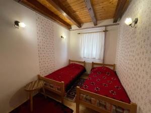 ZaovineにあるKonak Mandica avlijaのベッド2台と窓が備わる小さな客室です。