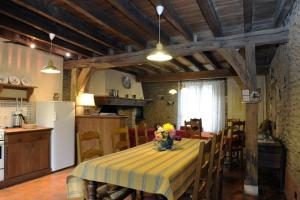 une cuisine avec une table et un chiffon de table jaune rayé dans l'établissement Les tavillons, à Soulaines-Dhuys