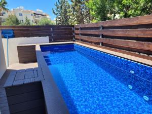 a swimming pool with blue water in a backyard at ELeAN VILLA in Paphos City