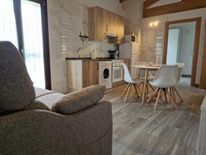 ein Wohnzimmer mit einer Couch und einem Tisch mit Stühlen in der Unterkunft Apartamentos Villa de Panes - La Plaza in Panes