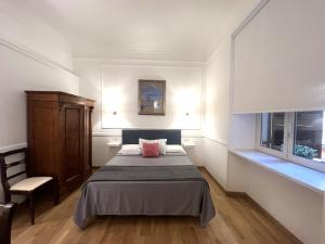 a bedroom with a bed and a chair and a window at INTERNO ROMA in Rome