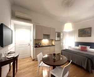 a bedroom with a bed and a table and a kitchen at INTERNO ROMA in Rome
