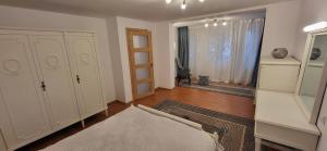 1 dormitorio con armarios blancos, 1 cama y ventana en Cotroceni Accommodations Upstairs, en Bucarest