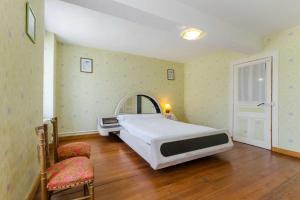 a bedroom with a large bed and two chairs at Les cas rouge 