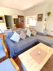een woonkamer met een blauwe bank en een tafel bij Tierra del Sur in Conil de la Frontera