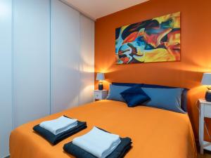 1 dormitorio con 1 cama grande de color naranja con almohadas azules en LE CELESTE - HYPERCENTRE PARKING ET NETFLIX GRATUITS PROCHE TRAMWAY ET PARC DE LA TETE D'OR, en Villeurbanne