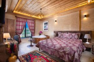 a bedroom with a large bed and a large window at Cappadocia Pyramid Stone House in Uçhisar