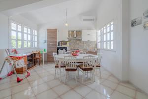 a kitchen and dining room with a white table and chairs at Appartamento con vista su Noto in Noto