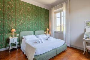 een slaapkamer met een bed met een groene muur bij Villa Agnese Suites in Lucca