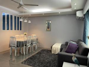 a living room with a couch and a table and chairs at Anavada Suites - Davao City in Davao City