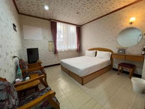 una camera da letto con un letto e una TV di Jiaoxi Hot Spring Hotel a Jiaoxi