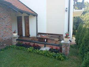 a porch of a house with a bench and flowers at Etno Dušnik in Gadžin Han