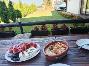 a table with a bowl of food and a plate of vegetables at Etno Dušnik in Gadžin Han