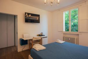 a bedroom with a blue bed and a desk at Locanda Dolcevita in Dozza