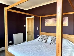 um quarto com uma cama com uma estrutura em madeira em The Lytham Cottage em Lytham St Annes