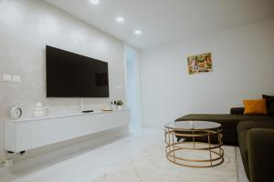 a living room with a couch and a tv on a wall at Apartman 007 in Vukovar