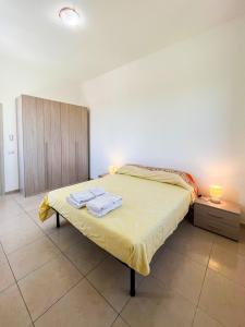 a bedroom with a bed with two towels on it at Villa Cecita Holiday in Sellia Marina