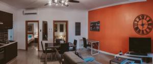 a living room with a couch and a clock on the wall at Lovely, central 2BR home, just off St Julians w/AC by 360 Estates in Is-Swieqi