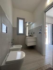 bagno con servizi igienici, lavandino e specchio di Domu Dina Affittacamere 3 a Tertenìa