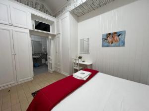 1 dormitorio con cama blanca y manta roja en hotel tiffany, en Varcaturo