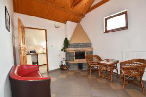 a living room with a fireplace and a table and chairs at Penzión Stefani in Smižany