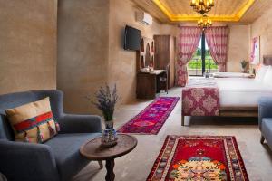 a hotel room with a bed and a couch and a table at Cappadocia Pyramid Stone House in Uçhisar