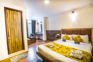 a bedroom with a large bed and a large window at Muscatel Dzeemkhang - 400 Mts from MG Marg in Gangtok