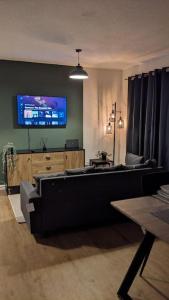 ein Wohnzimmer mit einem Sofa und einem TV an der Wand in der Unterkunft 2 Bedroom apartment in Brean in Brean