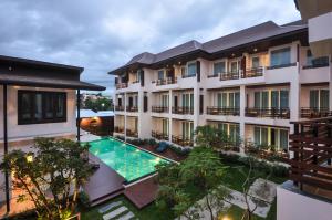 
a large building with a pool of water in front of it at Le Patta Hotel Chiang Rai SHA Extra Plus in Chiang Rai
