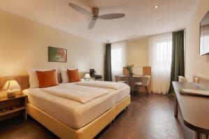 a bedroom with a large bed with a ceiling fan at homie hotel fischzucht in Würzburg +59 photos