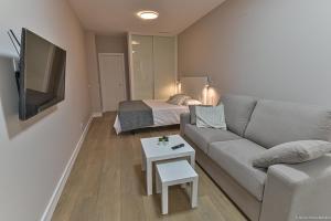 a living room with a couch and a bed at Apartamentos Bela in Cangas de Morrazo