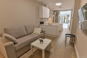 a living room with a couch and a table and a kitchen at Apartamentos Bela in Cangas de Morrazo