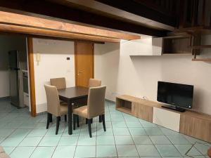 a dining room with a table and chairs and a television at Civico 13 in Bisceglie