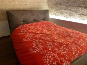 una coperta rossa su un letto con finestra di Civico 13 a Bisceglie