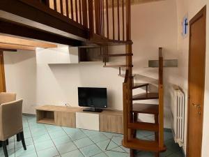 a living room with a tv and a staircase with a television at Civico 13 in Bisceglie