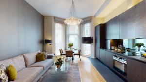 uma sala de estar com um sofá e uma mesa em The Harrington - Gloucester Road - 1 Harrington Gardens em Londres