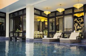 un vestíbulo con piscina en medio de un edificio en River Suites Hoi An, en Hoi An