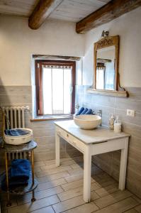 La salle de bains est pourvue de 2 lavabos et d'un miroir mural. dans l'établissement Chalet in pietra e legno con caminetto, à Inverso Pinasca